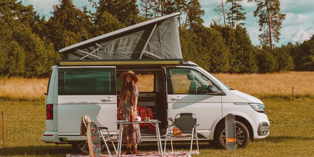 Frau steht vor dekoriertem Camper