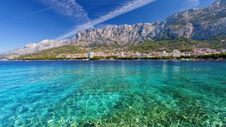 Klares Meerwasser vor dem Ort Makarska an der Küste von Kroatien mit Bergen im Hintergrund auf einem Urlaub in Kroatien