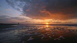 Sonnenuntergang mit strahlenden Farben im Urlaub mit dem Camper in Holland am Strand von Cadzand-Bad