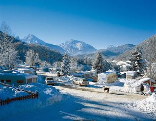 Der Campingplatz Allweglehen im Winter. Man sieht die Berge und einige Fahrzeuge auf dem Platz stehen.