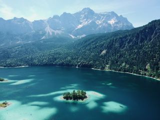 Der Eibsee umgeben von Bergen. Auch zu Eibsee Camping haben wir einen detaillierteren Artikel geschrieben.