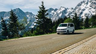 Ein CamperBoys Camper fährt auf einer Straße mit Bergpanorama