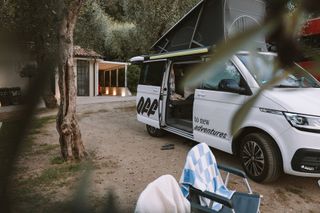 Ein California Ocean Camper steht beim Camping in Italien am Gardasee auf einem Campingplatz.