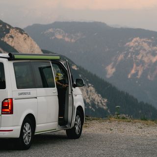 VW Camper von hinten mit Person, die aus dem Camper aussteigt