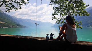 Woman sitting with coffee by the lake.