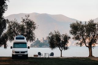 Der VW Grand California vor Flusspromenade mit Burg im Hintergrund