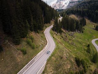 Drohnenaufnahme von einem Marco Polo Van, der eine Bergstraße entlangfährt.