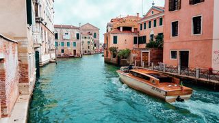 Channel with boat in the middle of houses