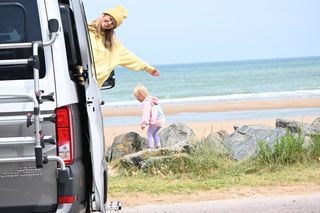 Mother and baby daughter in front of Campervan at the sea