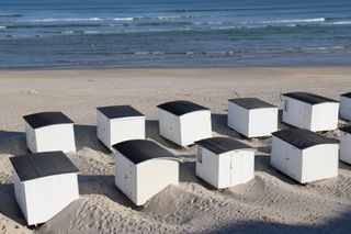 Weiße Strandhütten am Strand von Dänemark.