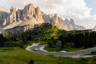 A van is driving down a road in the mountains.